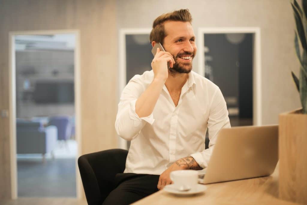 businessman on cellphone in front of laptop