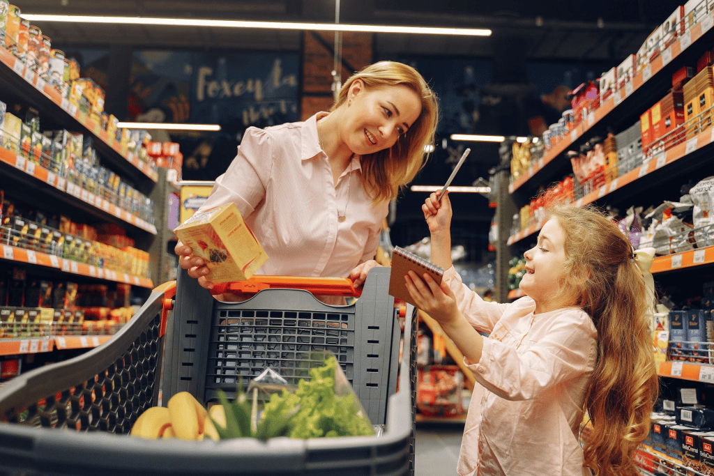 A woman and her young daughter buying groceries from a supermarket